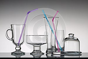 Glass cups with cocktail tubes and other utensils.