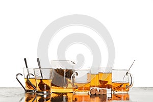 Glass cups and kettle on table. English breakfast tea. Copy space. White background. Bun fight and relax concept