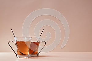 Glass cups with spoons. Tasty traditional english tea. Copy space for text. Pink background. Bun fight concept