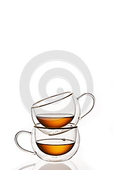 Glass cups with strong tea on white background, vertical frame