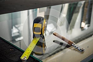 A glass cutter and a ruler lying on the glass pane at the Glass Factory