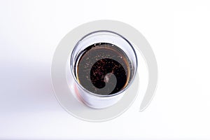 Glass with a dark drink isolated on a white background