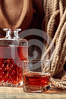 Glass and decanter with strong alcohol on a old wooden table