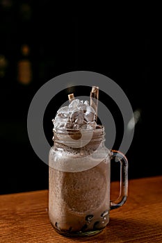 Glass of delicious chocolate milkshake on a bar counter