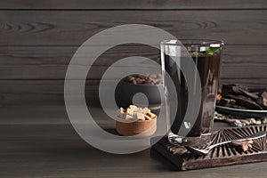 Glass of delicious hot chocolate on wooden table. Space for text