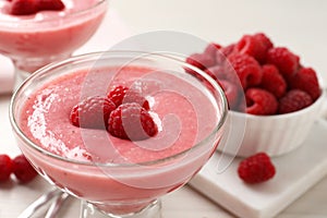 Glass of delicious raspberry mousse on table, closeup view