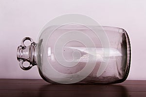 Glass demijohn against a light background