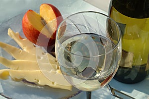 Glass of desert white wine with cheese and fruit, closeup