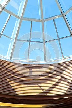 Glass dome constructions shadows in shopping mall in sunny day. Vertical photo