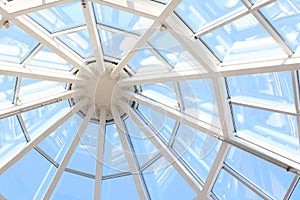 Glass dome with white structure in shopping mall in sunny day