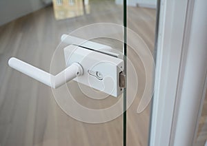Glass Door handle. Glass door knob with handle in open glass door modern room with wooden floor