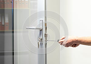 Glass Door knob repairing , worker Installs door knob, woodworker hands close-up