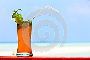 Glass of drink is on a beach table