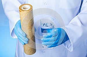 A glass of drink water and an used filter cartridge