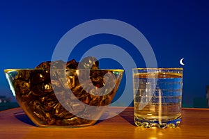 Glass of drinking water, dates and moon . Basic food and drink to break Ramadan fast. photo