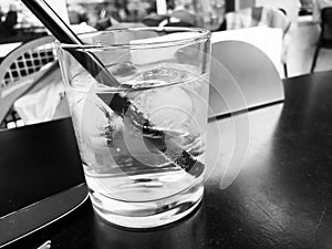 A glass of drinking water filled with ice on the wooden table