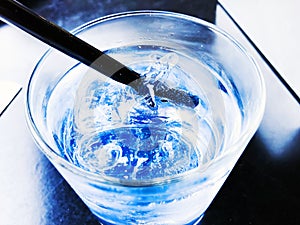 A glass of drinking water filled with ice on the wooden table