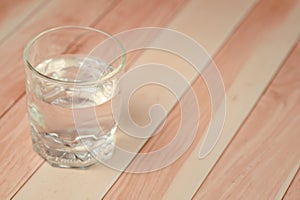 Glass of drinking water on wooden background with copy space, soft focus