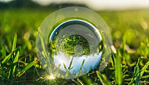 Glass Earth globe in green grass. Crystal sphere. Ecology and world environment day