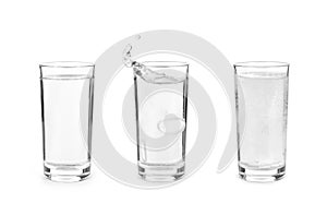 Glass with effervescent tablet in water with bubbles on white ba