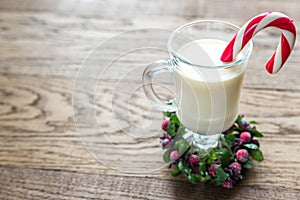 A glass of eggnog with candy cane