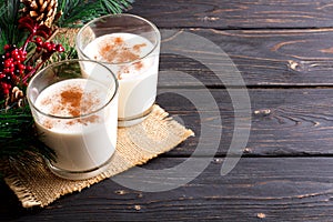 Glass of eggnog on wooden background