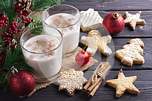 Glass of eggnog on wooden background