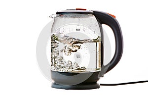 Glass electric kettle with boiling water on a white insulated background