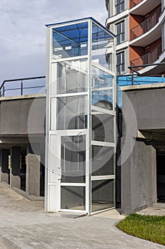 Glass elevator for disabled and disabled people at the entrance to a modern building. Caring for people