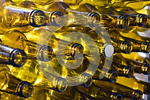 Glass empty beer bottles lie in rows, open the necks on the camera, one bottle with a cap