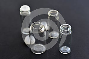 Glass empty bottles on a black background close-up. Pharmacy bottles in the afternoon in a group