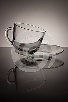Glass empty mug of tea and saucer on a black and white background
