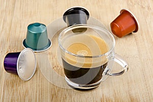 Glass of espresso with nespresso capsules