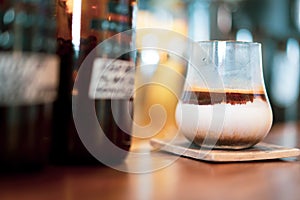 Glass of espresso shot with milk on bar at cafe