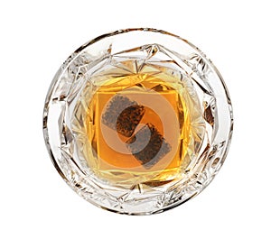 Glass of expensive whiskey with stones on white background