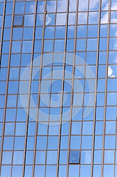 Glass facade background with blue sky reflection. Modern architecture and structure. Construction and design. Commercial