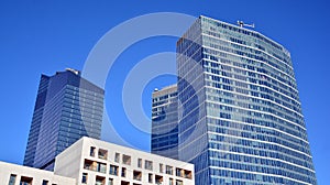 Glass facade of the buildings with a blue sky. Skyscrapers in the business city center.