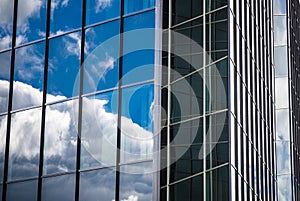 Glass facade of an office building with reflection of the sky, c