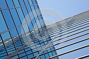 Glass facade of office building and reflections of blue sky