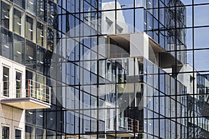 glass facade of an office building with reflections in the windows