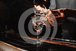 Glass of fiery cocktail on the bar counter