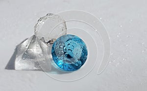 Glass figures, ball, stone and pyramid in drops of water
