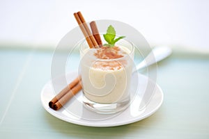 glass filled with creamy rice pudding drink, cinnamon stick garnish