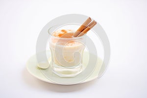 glass filled with creamy rice pudding drink, cinnamon stick garnish