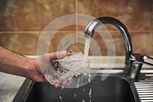 Glass filled with drinking water from kitchen faucet