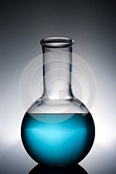 Glass flask placed in a laboratory table with blue liquid