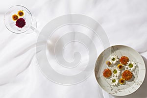 Glass with floating flowers and a plate with floating flowers