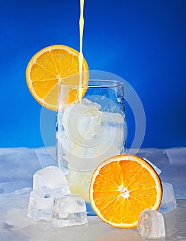In a glass flows fresh citrus juice.