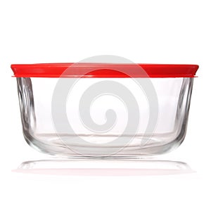 Glass food container with red plastic lid on white