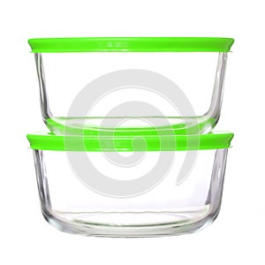 Glass food containers with green plastic lids on white